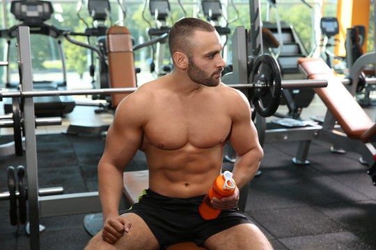 Portrait of athletic man with protein shake in gym
