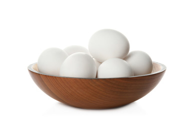 Bowl with raw chicken eggs on white background