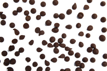 Delicious dark chocolate chips on white background, flat lay