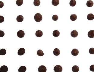 Delicious dark chocolate chips on white background, flat lay