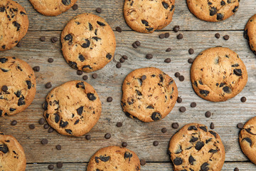 Delicious chocolate chip cookies on wooden table, flat lay