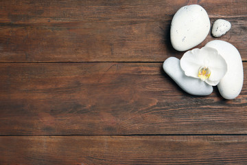 Flat lay composition with spa stones and space for text on wooden background