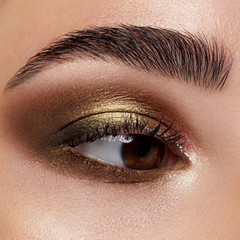 Fototapeta premium Zamknij się niebieskie oko kobiety z pięknym brązowym z odcieniami czerwieni i pomarańczy smokey eyes makeup. Nowoczesny makijaż.