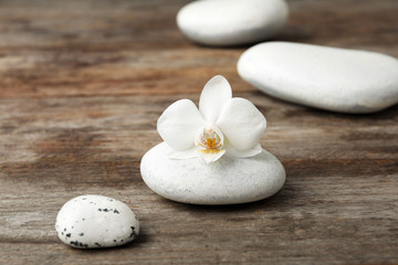 Spa stones and orchid on wooden table
