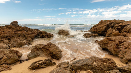 Fototapeta na wymiar Waves washing in on rocky island beach