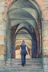 Fototapeta na wymiar Young woman walks up a set of medieval steep steps
