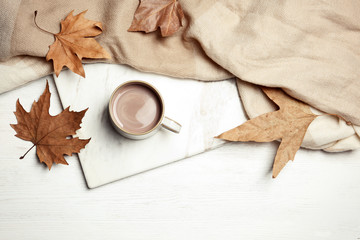 Naklejka na ściany i meble Flat lay composition with hot cozy drink and autumn leaves on wooden background