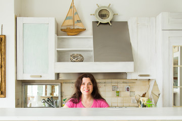 Housewives, emotions and people concept - Happy young woman in the kitchen at home