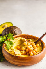 Avocado hummus in a wooden bowl with vegetables, copy space.