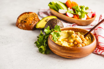 Avocado hummus in a wooden bowl with vegetables.