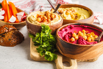 Different hummus bowls. Chickpea hummus, avocado hummus and beetroot hummus.