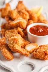 Fried Breaded chicken with tomato sauce on a white board.