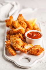 Fried Breaded chicken with tomato sauce on a white board.