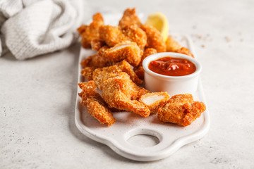 Fried Breaded chicken with tomato sauce on a white board.