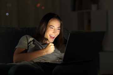 Excited girl checking online news in the night