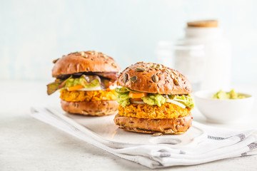 Vegan sweet potato (or pumpkin) burgers on white background. Vegetable burgers, avocado, vegetables and buns. © vaaseenaa