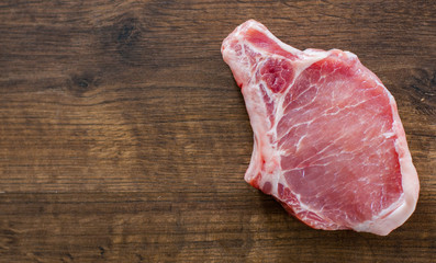 Raw Pork Loin chops meat on wooden table background with copy space. top view
