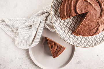 Vegan chocolate cake on a white dish for cake, top view, copy space.