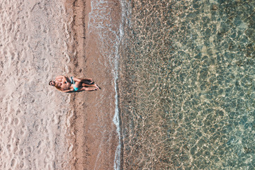 Fototapeta premium Aerial view on a young couple lying on the beach