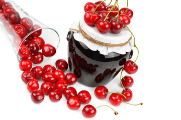 Cherries and jars of jam isolated on a white.