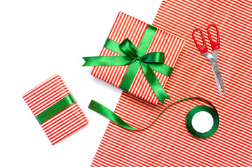 Gift boxes, packing paper, scissors, ribbon on white background. Festive background,...