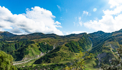 Fototapeta na wymiar Mountain hill path road panoramic landscape, clouds in the blue sky, summer sunny day
