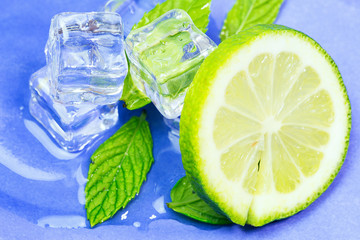 Ice with mint on light background. Ice cubes and mint leaves isolated on blue background