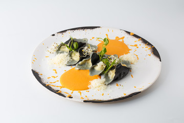 ravioli with cheese and sauce on a white plate isolated on white background