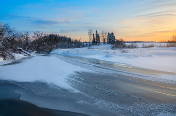 Frosty winter landscape with frozen ice bound river.