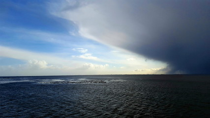 Obraz premium große graue Regenwolke über dem dunklen Meer am Horizont