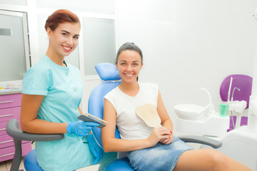 Beautiful female patient with dental treatment in the dentist office. A woman visiting her dentist. Women look into the camera