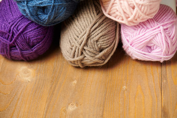 colorful wool yarn for knitting on wooden background