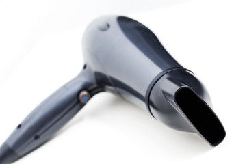 Black hair dryer on white background. View in perspective.