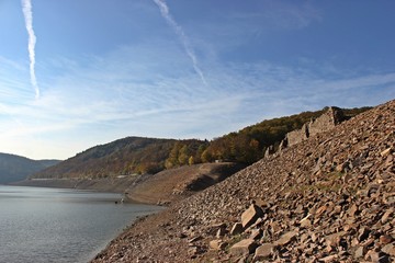 Blick auf die aufgetauchten Mauern der Dorfstelle Berich, die Bericher Hütte und den Taucherbaum am Ufer des extrem leeren Edersees 