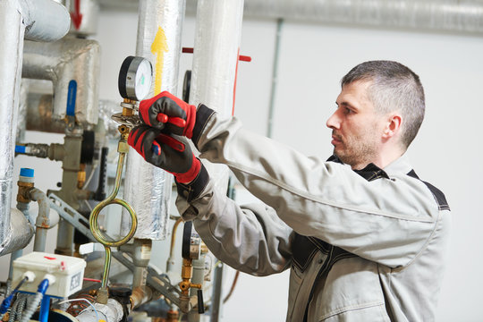 Heating Engineer Or Plumber In Boiler Room Installing Or Adjusting Manometer