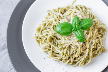 Cooked spaghetti pasta on a plate with basil pesto and Parmesan cheese, Italy food, healthy concept, vegetarian
