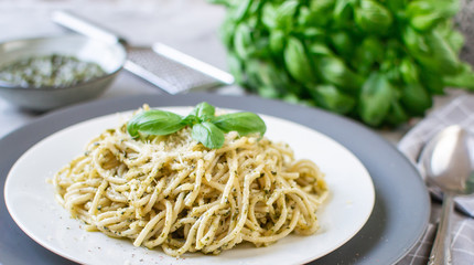 Cooked spaghetti pasta on a plate with basil pesto and Parmesan cheese, Italy food, healthy concept, vegetarian