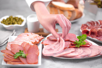 девушка делает бутерброд с вареной колбасой