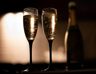 Two elegant champagne glasses on a dark surface on the kitchen
