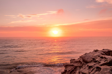 Fototapeta premium Sunrise over the ocean. Pink and orange hues. Warn sunny day.