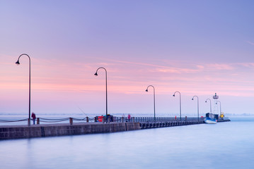 morning silence above pier with street lighters and smooth water in the sea