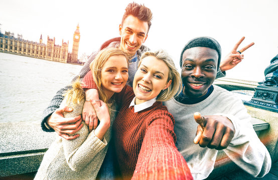 Happy multiracial friends group taking selfie in London at european trip - Young people addicted by sharing stories on social network community - Millennials lifestyle concept on vivid contrast filter