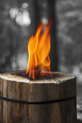 Fire from a Swedish candle is handmade of wooden logs. Close-up