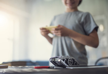 Detailed metal mechanism placed on the table and smiling boy looking at it