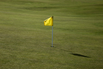 Obraz premium Yellow Flag on a Golf Course