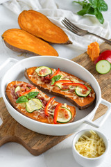 Baked sweet potato with bacon, sour cream, zucchini, red pepper and cheddar cheese.