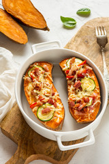 Baked sweet potato with bacon, sour cream, zucchini, red pepper and cheddar cheese.