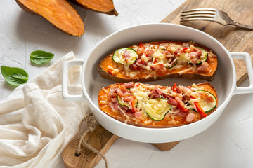 Baked sweet potato with bacon, sour cream, zucchini, red pepper and cheddar cheese.