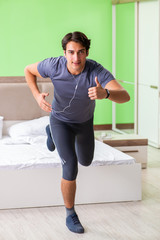 Young handsome man doing morning exercises in the hotel room