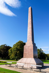 Obraz premium A few benches in front of remarkable McGrigor obelisk in Duthie park, Aberdeen, Scotland